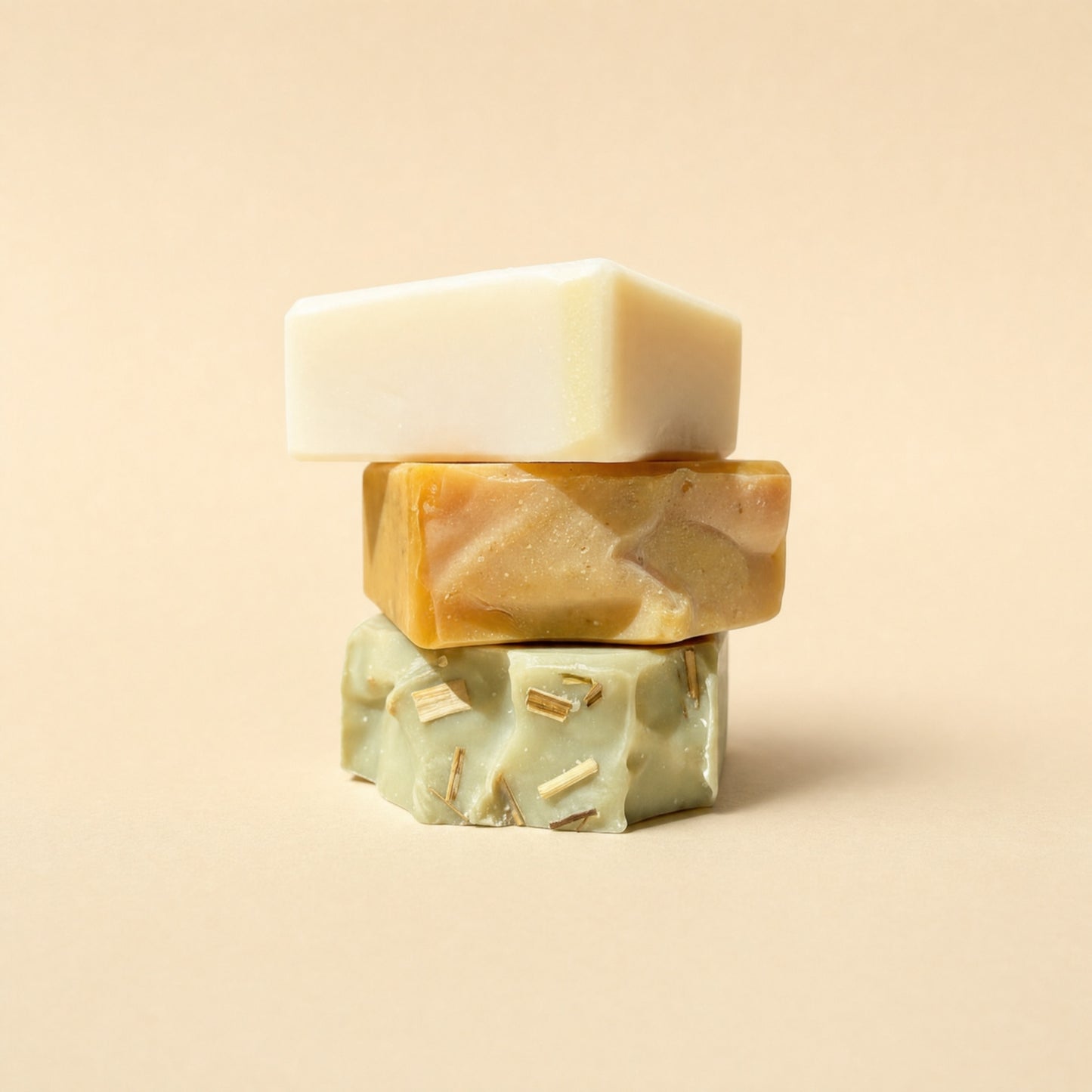 Three BioPulse tallow soap bars stacked on a cream background: cream, marbled orange and green with lemongrass