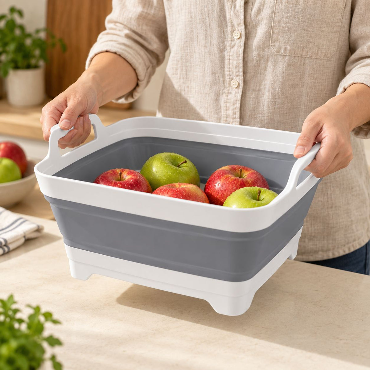 A person holding FreshDip Fold by both carry handles with produce inside.