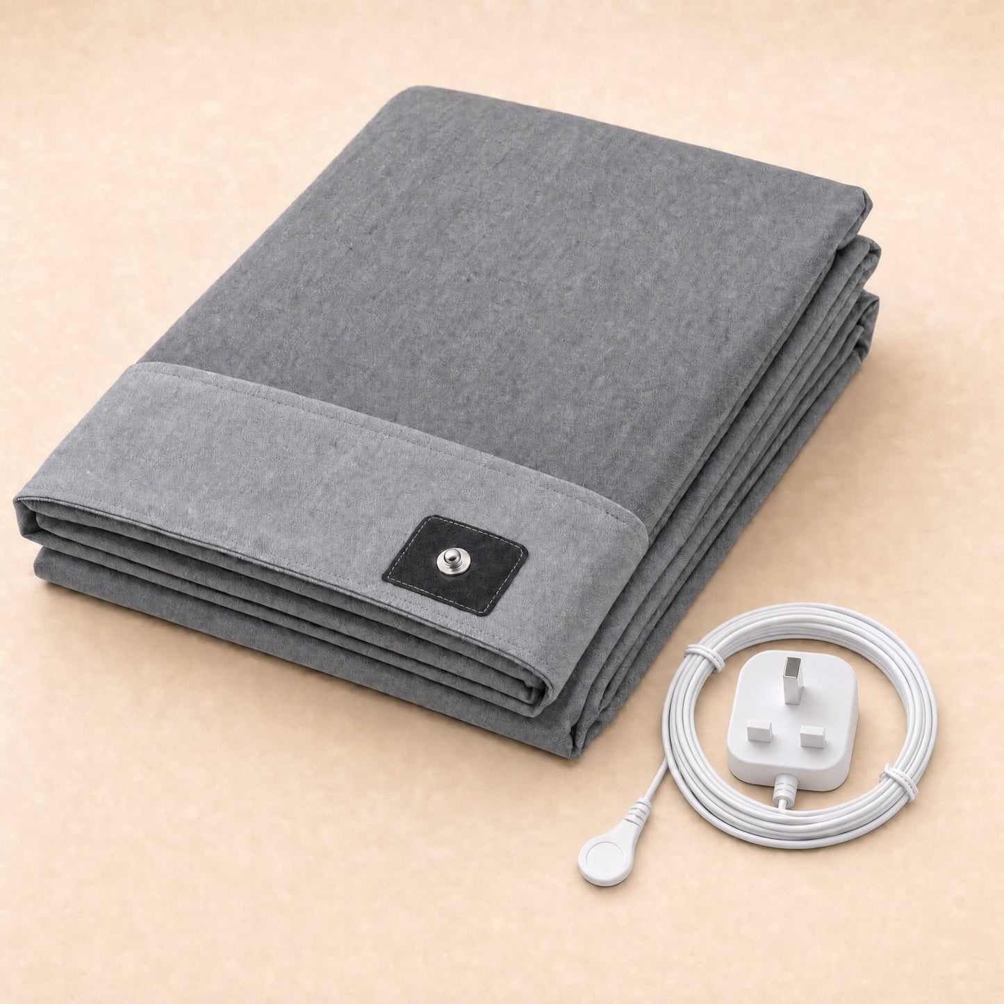 Folded grey BioPulse Earthing Bed Sheet with snap connector and coiled cord with UK plug