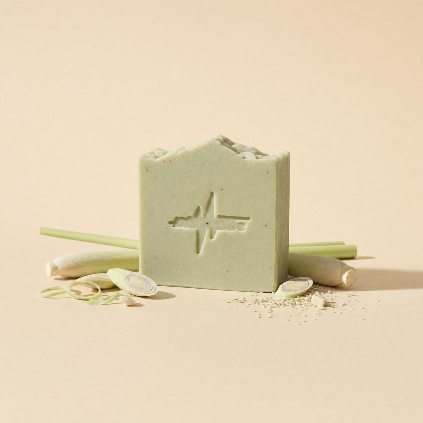 Green BioPulse tallow soap bar with embossed logo standing beside fresh lemongrass stalks and slices