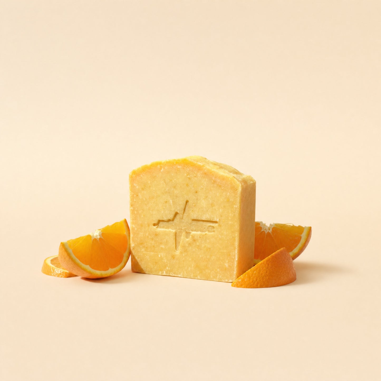BioPulse Organic Tallow Soap orange bar with the pulse logo stamp, beside fresh orange slices