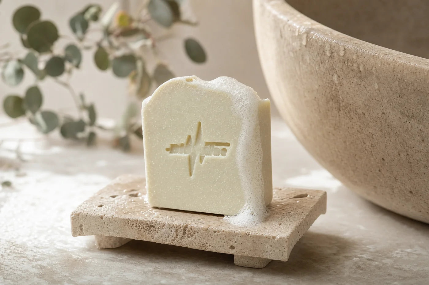 A BioPulse tallow soap bar lathering on a travertine dish